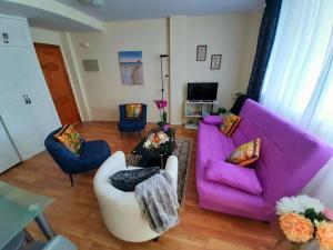 a living room with a purple couch and chairs at Ocean Orchidea in Puerto de la Cruz