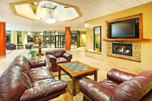 a living room with leather furniture and a fireplace at Holiday Inn Johnson City by IHG in Johnson City