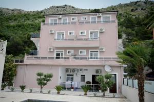 a pink building with a hill in the background at Hotel 'DEL MAR' - Shengjin in Shëngjin