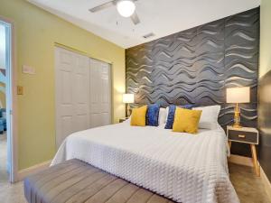 1 dormitorio con 1 cama grande con almohadas amarillas y azules en Large GAY MEN'S 1 bedroom w Gameroom heated pool clothing optional, en Fort Lauderdale