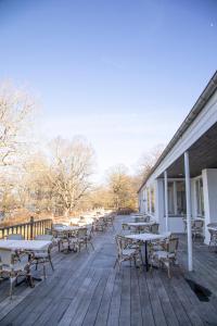 eine Terrasse mit Tischen und Stühlen an einem Gebäude in der Unterkunft Hotel Strandparken in Holbæk