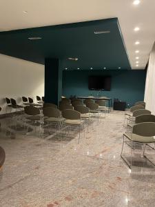 a room with a bunch of chairs and a screen at Cristal Palace Hotel in Andria