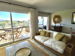 sala de estar con sofá blanco y balcón en Duplex vistas al golf Guadalmina Marbella, en Marbella