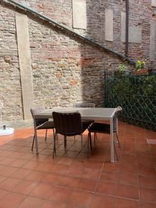 einen Tisch und Stühle neben einer Ziegelwand in der Unterkunft Cozy Flat in Piemonte in Acqui Terme