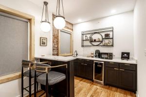 a kitchen with black cabinets and two bar stools at Historic DTWN Studio, Walk to Bathhouses, Shops, Room # 103 in Hot Springs