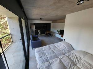 Una sala de estar con un sofá y una cocina. en Monoambiente 2do piso de calidad en Pichincha, en Rosario