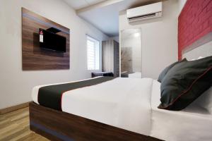 a bedroom with a white bed and a tv at Hotel Kalinga Bapuji Nagar in Bhubaneshwar