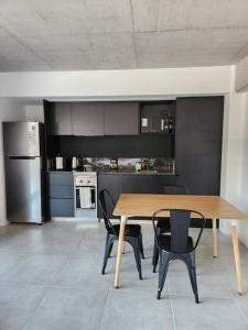 Una cocina con una mesa de madera y sillas negras. en Monoambiente 2do piso de calidad en Pichincha, en Rosario