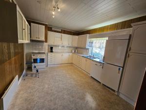 a kitchen with white cabinets and a white refrigerator at Sandmo Holiday Home 11 in Eckerö +8 photos