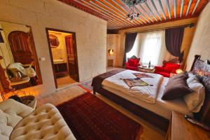 a bedroom with a large bed and a living room at Cappadocia Cave Sinasos in Nevşehir