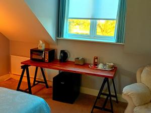 a room with a table with a microwave and a window at White Quarry Hse Quarry Road in Navan