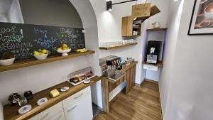 a kitchen with a counter with food and a chalkboard at Guest House Mlada lipa in Maribor