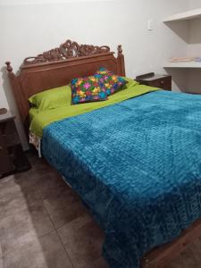 a bedroom with a bed with a blue comforter at Departamento La Plazoleta in San Fernando del Valle de Catamarca