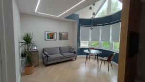 London Studios and Suites في هارو: غرفة معيشة مع أريكة وطاولة