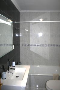 La salle de bains est pourvue d'un lavabo, d'une baignoire et de toilettes. dans l'établissement DOM ELENA - JARDINS DA ROCHA, à Portimão