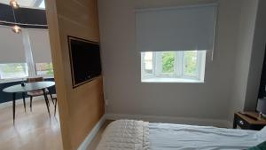 1 dormitorio con cama, ventana y mesa en London Studios and Suites, en Harrow