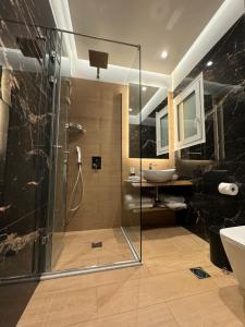 uma casa de banho com um chuveiro e um lavatório. em Mirada Hotel em Atenas