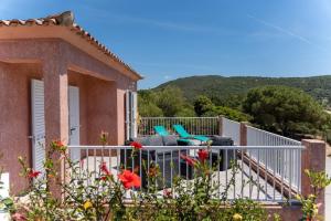 ein Haus mit einem Balkon mit zwei Stühlen darauf in der Unterkunft Villa Tizzano Vue Mer in Sartène