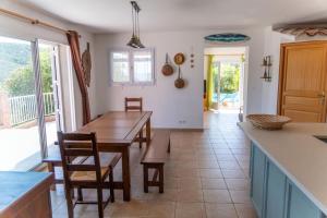 eine Küche mit Holztisch und ein Esszimmer in der Unterkunft Villa Tizzano Vue Mer in Sartène