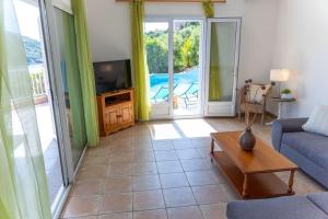 ein Wohnzimmer mit Sofa und Fernseher in der Unterkunft Villa Tizzano Vue Mer in Sartène