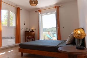 ein Schlafzimmer mit einem Bett und einem Tisch und einem Fenster in der Unterkunft Villa Tizzano Vue Mer in Sartène + 43 Fotos