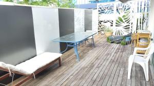 un patio avec une table bleue et des chaises sur une terrasse dans l'établissement HILLTOP CBD SUITES, à Brisbane 20 autres photos