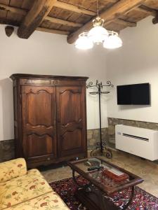 ein Wohnzimmer mit einem großen Holzschrank und einem Tisch in der Unterkunft Il Rifugio del Pellegrino in Vetralla