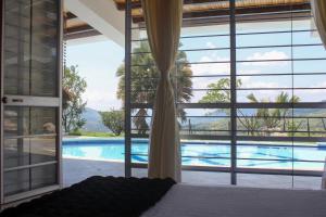 una camera da letto con finestra affacciata sulla piscina di CASA MERAK - Inspira tu vida a Oiba