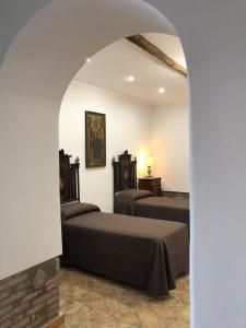 1 Schlafzimmer mit 2 Betten und einem Torbogen in der Unterkunft Il Rifugio del Pellegrino in Vetralla