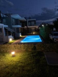 a swimming pool at night with a candle in the yard at Paralia Ofrinio - Beach Apartments in Ofrínion +27 photos