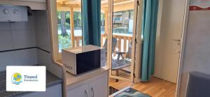 a tv sitting on a dresser in a tiny house at Comfortable campsite-chalet G8 Tuscany near sea in Viareggio
