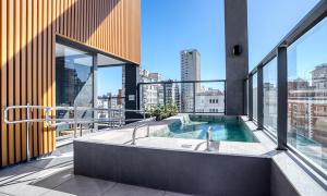 a balcony with a bath tub on top of a building at Tabas - Pivô Match Jardins - Cravinhos in Sao Paulo