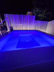 una piscina con luci blu di fronte a una recinzione di Zoumis Residence a Naoussa
