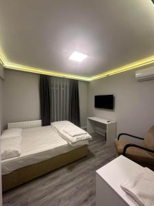 sypialnia z łóżkiem, telewizorem i kanapą w obiekcie Aslan Airport Hotel w mieście Arnavutköy