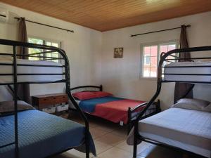 a room with three bunk beds and a window at Hotel Cabañas Casita La Ermita in San Carlos
