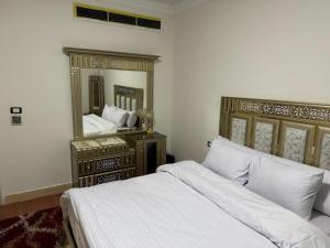 a bedroom with two beds and a large mirror at فيلا كمبوند رويال سيتي in Sheikh Zayed