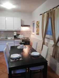cocina con mesa negra y sillas y comedor en Apartments Poretti for 2,in Center Parking Free in the yard,6 min beach walk, en Rovinj