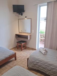 een slaapkamer met 2 bedden, een wastafel en een spiegel bij Asteri Studios in Kalamaki