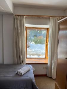 1 dormitorio con cama y ventana en Loft Catedral by Base 41 en San Carlos de Bariloche