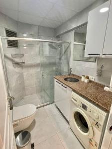 ein Badezimmer mit einem Waschbecken und einer Waschmaschine in der Unterkunft Lavina Apartments in Istanbul