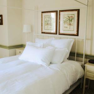 a white bed with white pillows in a bedroom at Mary's Land Farm in Ellicott City
