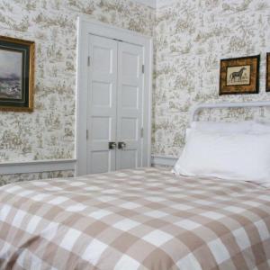 a bedroom with a bed with a checkered blanket at Mary's Land Farm in Ellicott City