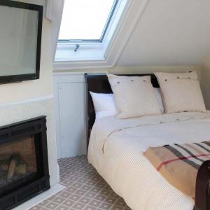 1 dormitorio con 1 cama junto a la chimenea en Mary's Land Farm en Ellicott City