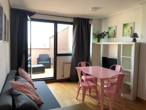 uma sala de estar com uma mesa rosa e cadeiras em Apartamento El Ático de Celorio em Celorio