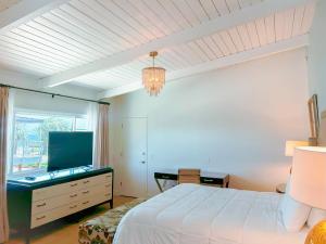 Pacific Crest Hotel Santa Barbara في سانتا باربرا: غرفة نوم مع سرير وخزانة مع تلفزيون