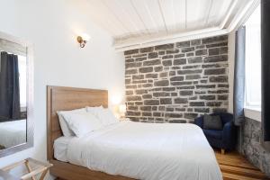 a bedroom with a bed and a brick wall at Auberge Internationale de Quebec - HI CANADA in Quebec City