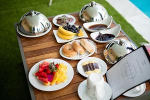 a table with plates of food on top of it at Jazuri Villa in Buccoo
