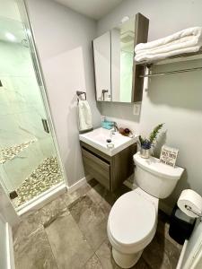 a bathroom with a toilet and a sink and a shower at Modern Cozy Home W Free Parking- Close to Downtown & Beach in Victoria +16 photos