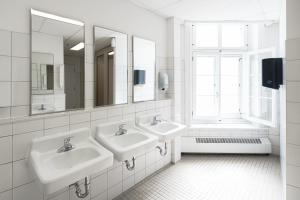 Baño blanco con 2 lavabos y ventana en Auberge Internationale de Quebec - HI CANADA en Quebec