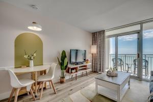 un soggiorno con un tavolo e una TV di Newly renovated Stylish Beach Condo for 6 Camelot 15th Fl a Myrtle Beach
